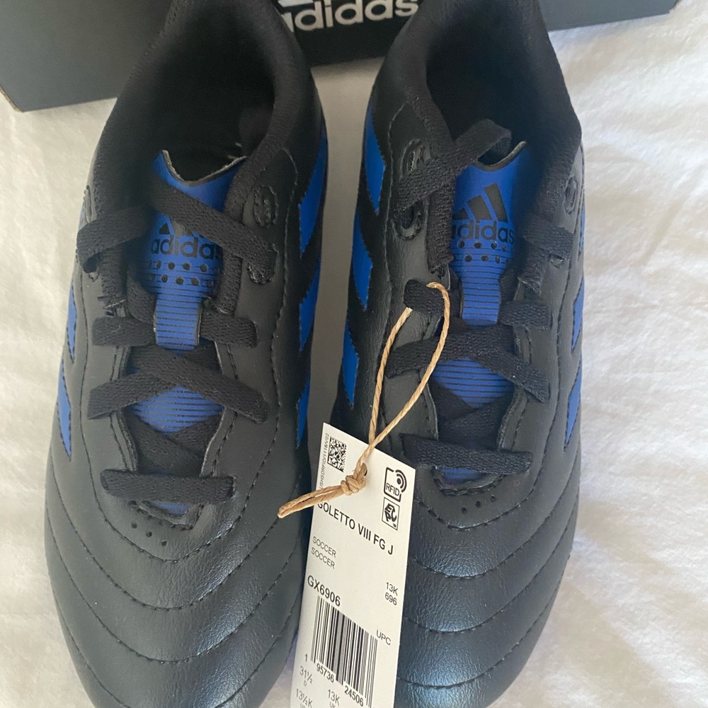 Brand new in box, adidas blue and black soccer cleats, size 13.5
